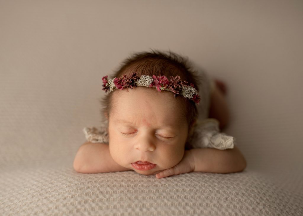 newborn with her head on her hands