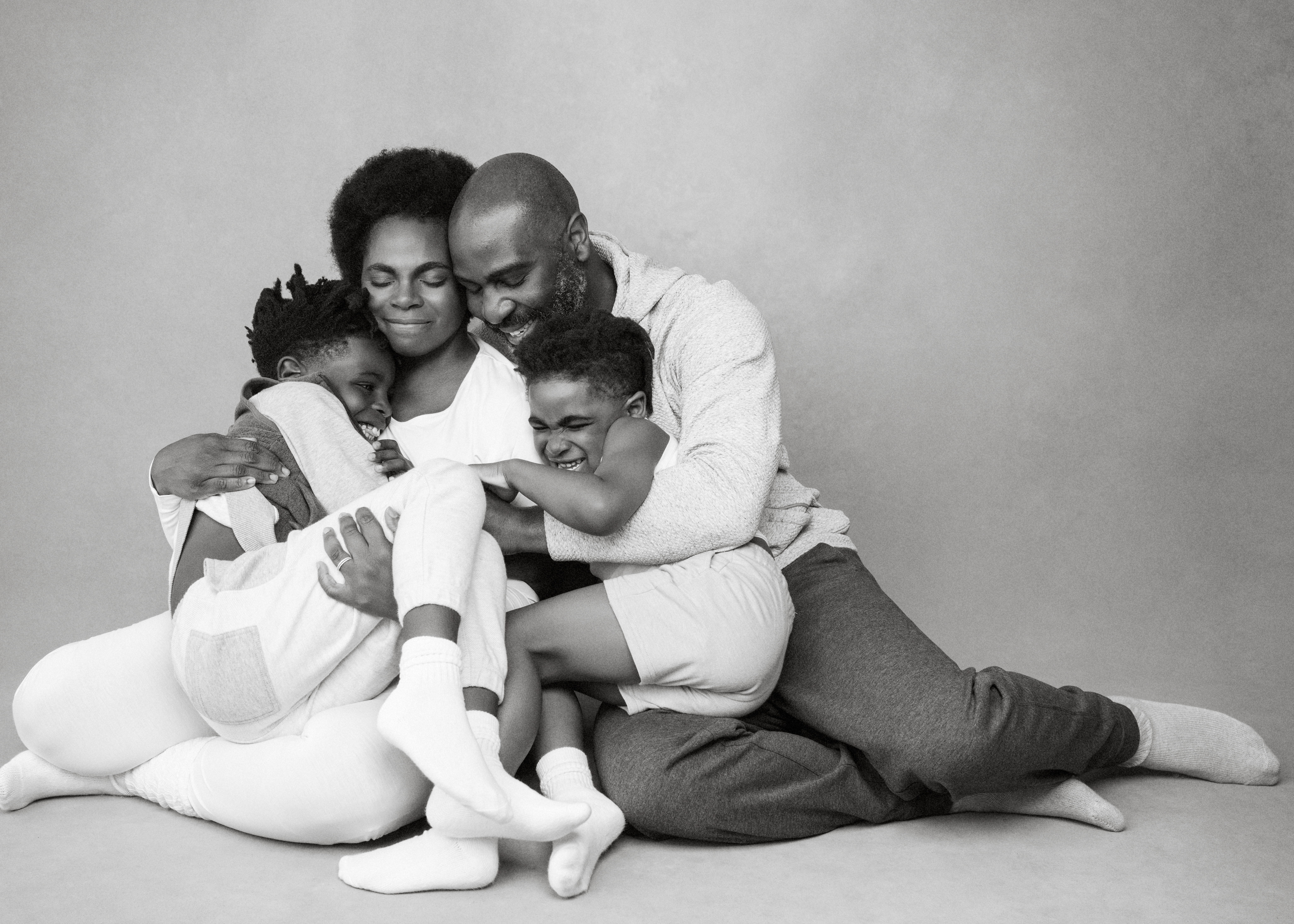 Black and white image of family embracing each other in Wauwatosa photography studio